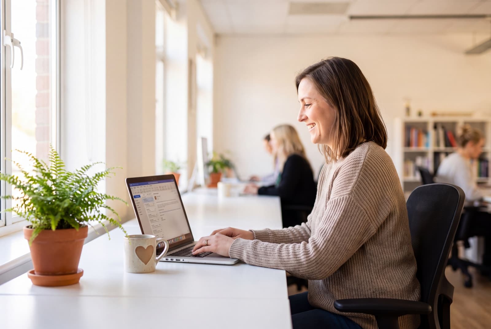 A support specialist replying to a customer email at a bright modern desk